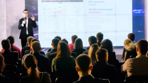 David presenting to a seated audience in front of a projected slide