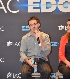 David on a panel at IAC EDGE holding a microphone
