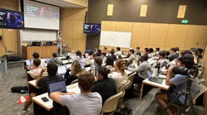 David presenting to a packed university classroom in front of a large screen