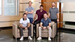 Four co-founders posing in an office lobby