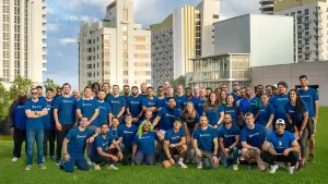 Company team photo outdoors in matching blue shirts