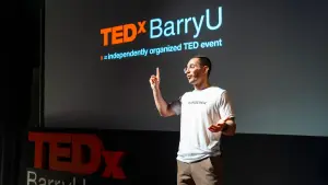 David speaking on stage at TEDxBarryU