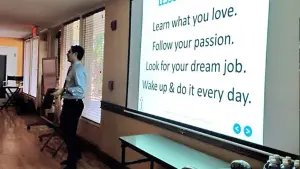 David beside a projected slide ("Learn what you love. Follow your passion. Look for your dream job.")