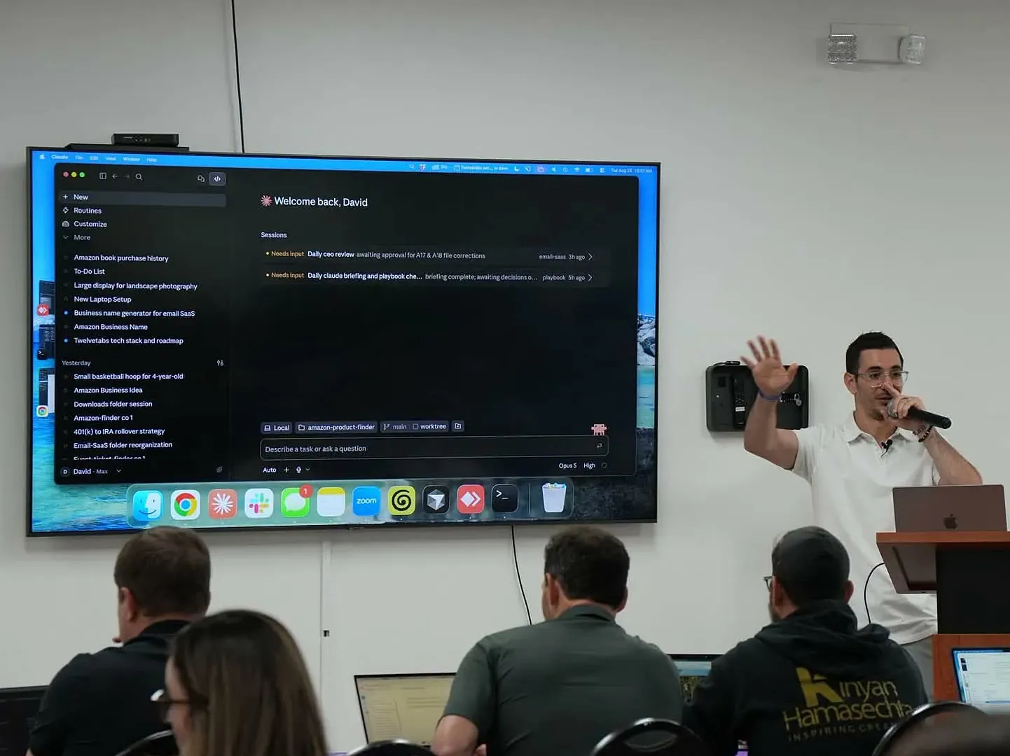 David teaching a Claude class beside a large screen showing Claude