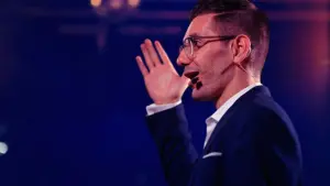 Close-up, headset mic, hand raised, blue stage light